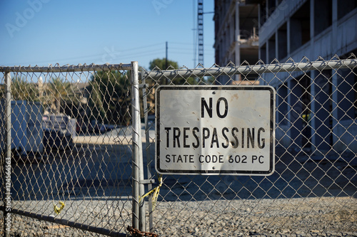 no trespassing sign on fence of construction site