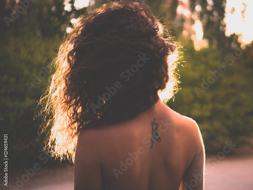 woman with bare back tattoo ballet slippers night outdoors