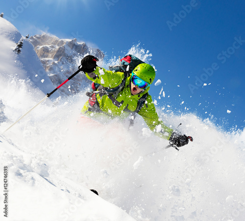 Freeride skier on piste running downhill
