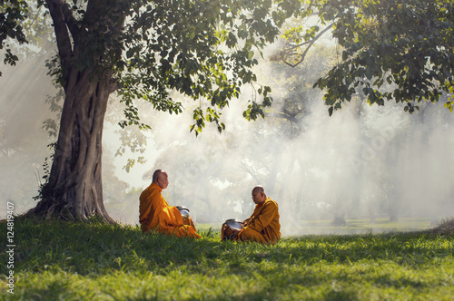 Two monks meditation under the trees with sun ray, Buddha religi