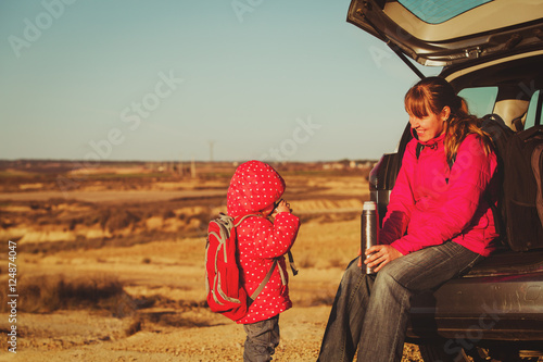 mother and little daughter travel by car in mountains