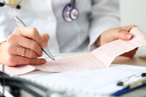 Doctor hands with cardiogram chart on clipboard pad