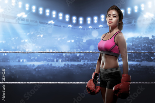 Concentrated asian woman with boxing gloves