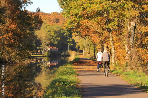 Ballade en vélo/ Ballade en vélo à la campagne le long d'un canal en automne