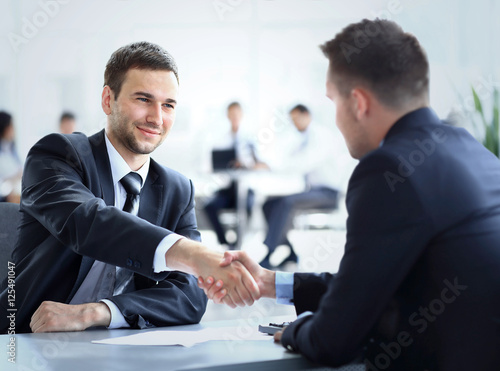 Two business colleagues shaking hands during meeting