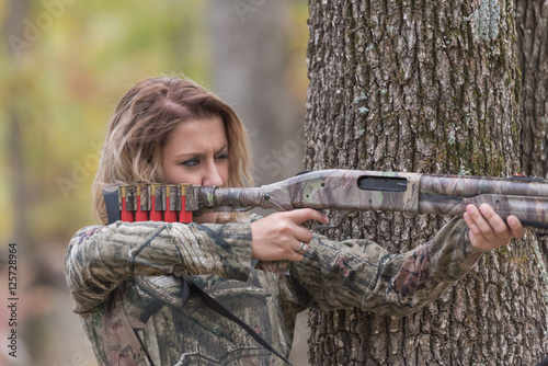 Woman hunting and aiming a shotgun