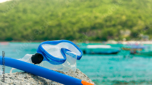 Snorkeling equipment: snorkel and diving google on the stone. Tr