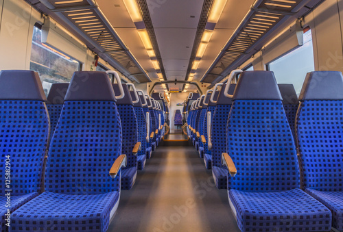 Empty train chairs - Image with the interior of a german modern train, with no people on the blue chairs