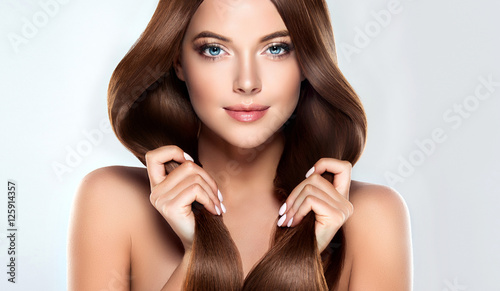 eautiful model girl with shiny brown straight long hair . Care and hair products . 