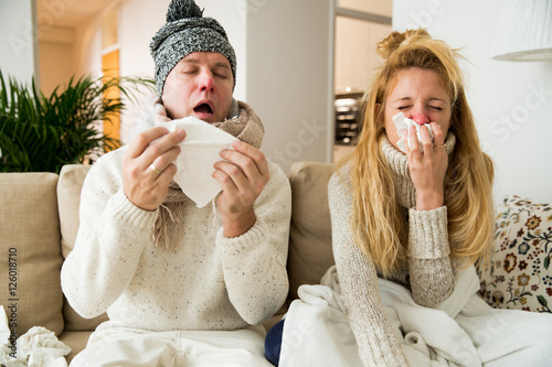 Sick couple catch cold. Man and woman sneezing, coughing, got flu, having runny nose.