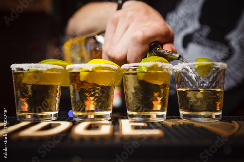 Barman pours tequila closeup club