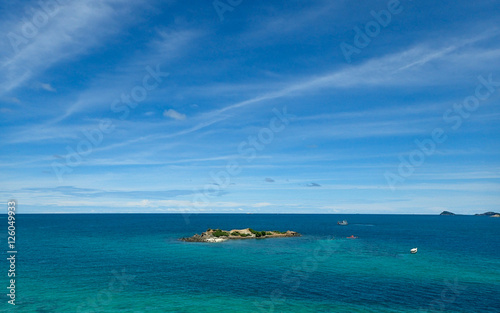 Island, clear seawater and blue sky background