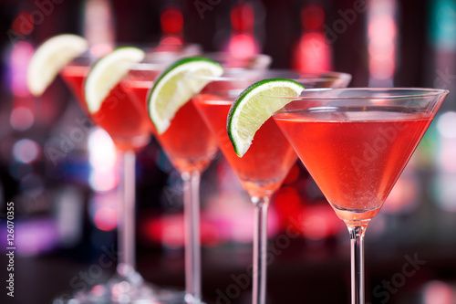 Row of Cosmopolitan cocktails shot on a bar counter in a nightcl