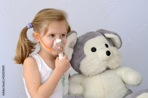 Child, kid (little girl) with inhaler (nebulizer) makes the procedure.