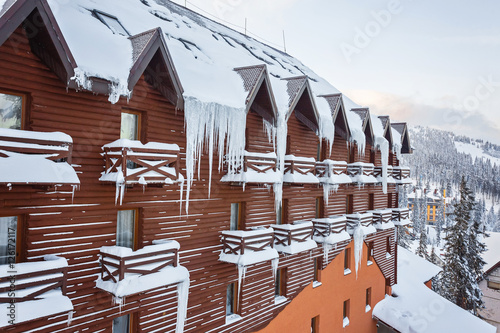 Long and dangerous icicles on a house roof over balcony