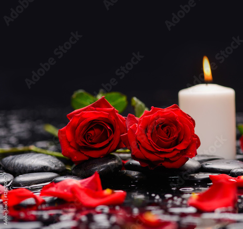 Red rose with petals with candle and therapy stones