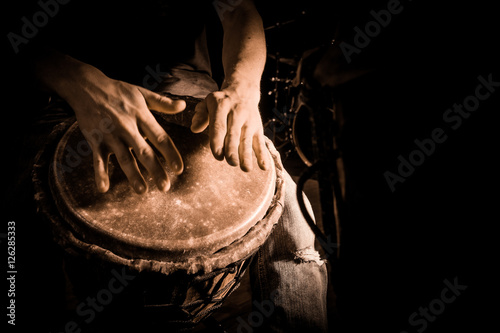 People hands playing music at djembe drums