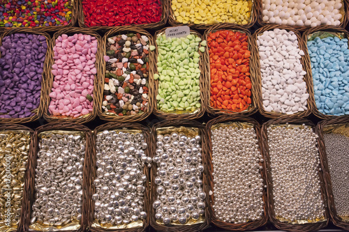 sweets, jelly beans of different colors, in baskets on the shelves