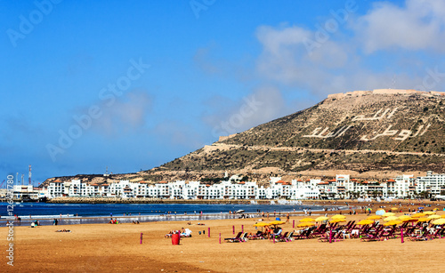 Der breite kilometerlange Strand von Agadir gegenüber Kasbah Berg mit dem Schriftzug: Gott, Vaterland, König 