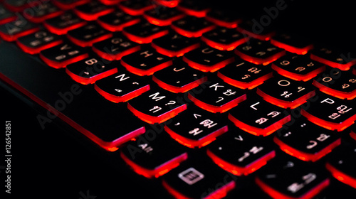 Close up. Red backlight, backlit on laptop computer or keyborad computer of gaming in the dark. Concept Thai computer keyboard background.