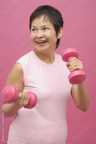 Mature woman using dumbbells