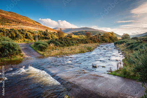 Ford on College Burn and The Cheviot, from which the hill range takes its name, is the highest point in Northumberland, located in the Anglo-Scottish borders, seen here in autumn from College Valley