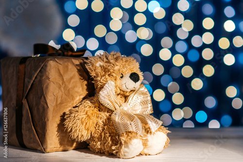 Gift box and teddy bear, a gift for the child. Shimmering background, place for text