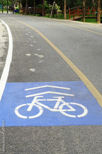 Bicycle sign path on road. Bikes lane paint in blue.