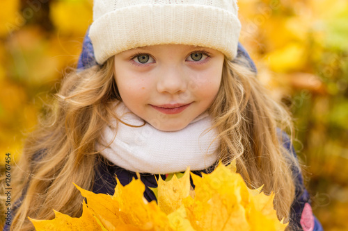 Portrait of a beautiful girl in a blue coat outdoors in autumn