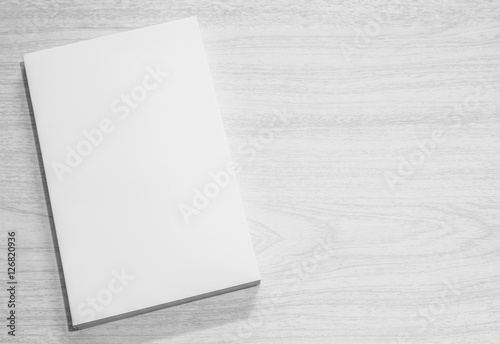 Real 3D paperback white book on a wood background
