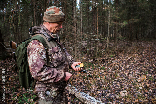Man hunter with a gps navigator in the forest. Orienteering in the forest, a route map. Technology, Gadget.