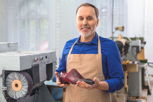 cobbler holding a brand new footwear