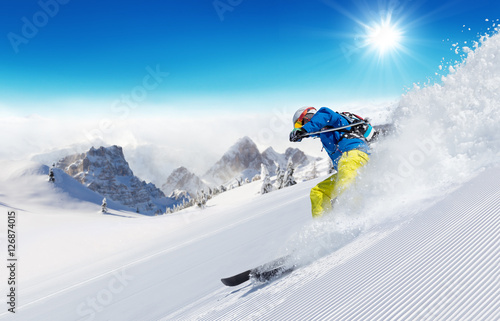 Skier on piste running downhill