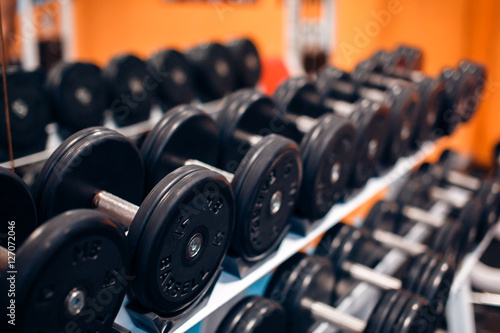 View of rows of dumbbells on a rack in a gym