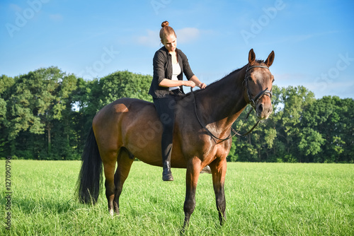 Junge Frau reitet ohne Sattel auf einem Pferd