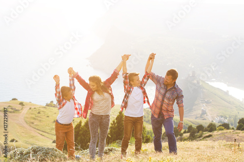 Family of four people looking to beautiful seascape in mountains