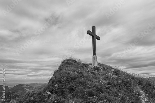 Black and white image of a cross on hillside in the Swiss alps