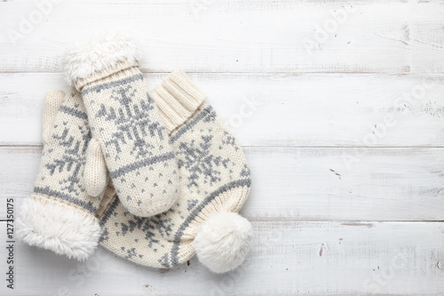 Winter background with knitted mittens and cap