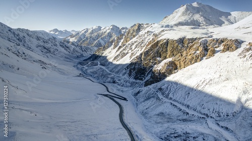 Aerial photo of Barskoon gorge with snow and serpentine road. Kyrgyzstan