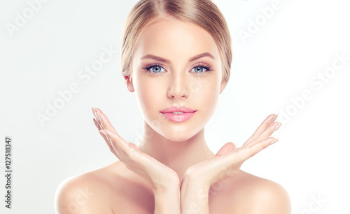 Beautiful Young Woman with clean fresh skin . Facial treatment . Cosmetology , beauty and spa . 