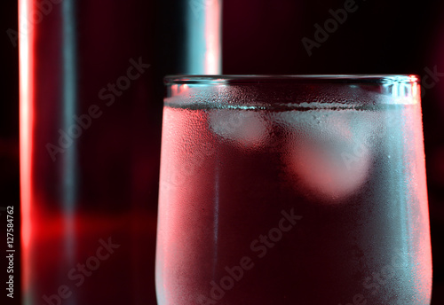 oszronione szklanki z zimnymi drinkami z lodem na czerwonym tle