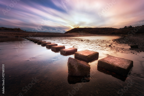 Three Cliffs Bay stepping stones Sunset at the stepping stones that allow access to the divided beaches at Three Cliffs Bay on the Gower peninsula in Swansea, South Wales