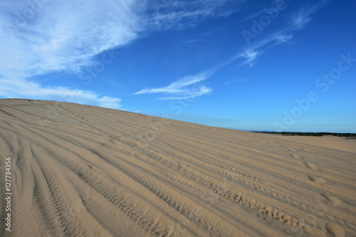 Blue cloudy sky over sand dunes in the evening