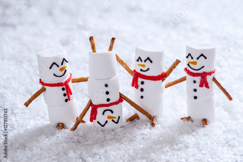 Happy funny marshmallow snowmans on snow