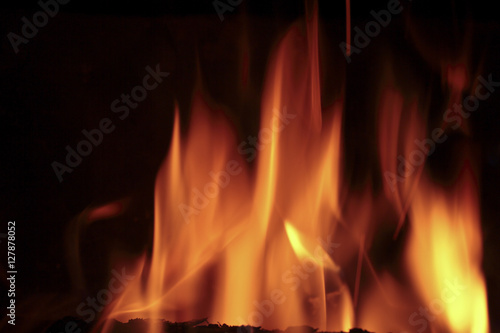 Flames of fire in a fireplace. Shooting horizontal with tones Orange and black.