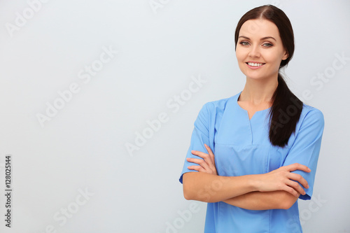 Smiling female doctor on light background