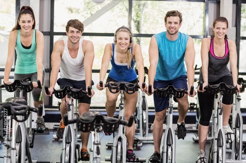 Fit group of people using exercise bike together