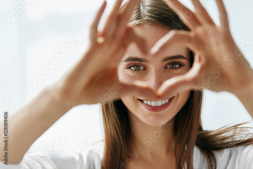 Beautiful Happy Woman Showing Love Sign Near Eyes.