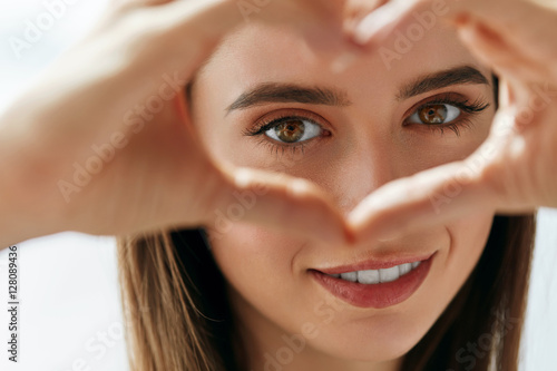 Beautiful Happy Woman Showing Love Sign Near Eyes.