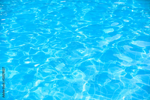 Blue and bright water in swimming pol with sun reflection